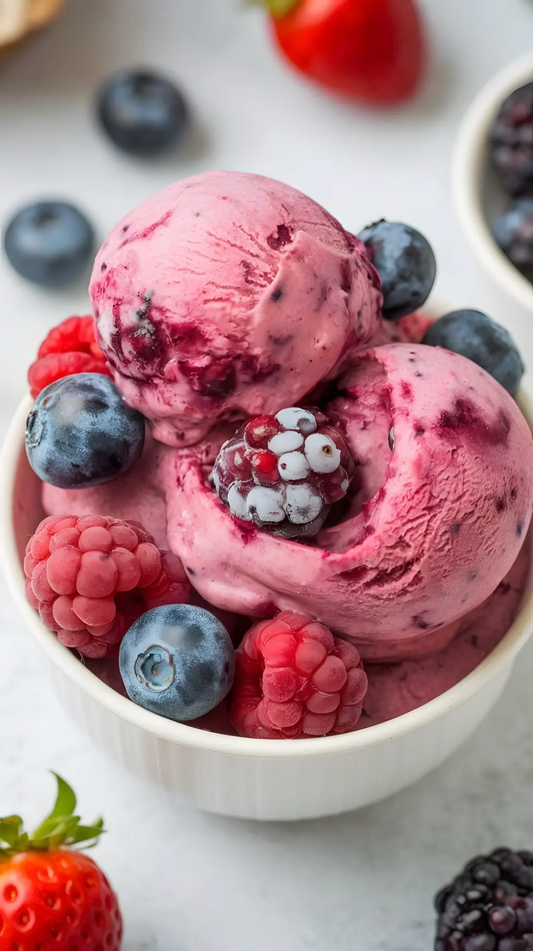 A bowl of berry nice cream topped with fresh berries